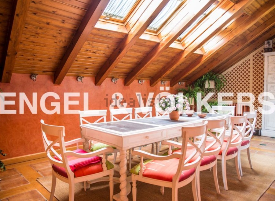 Charming attic dining area with wooden beams and skylights, creating a bright and airy atmosphere.