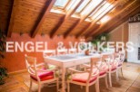 Charming attic dining area with wooden beams and skylights, creating a bright and airy atmosphere.
