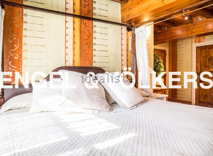 This luxurious bedroom boasts a stunning hand-painted headboard and a comfortable four-poster bed.