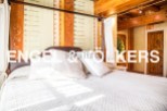 This luxurious bedroom boasts a stunning hand-painted headboard and a comfortable four-poster bed.