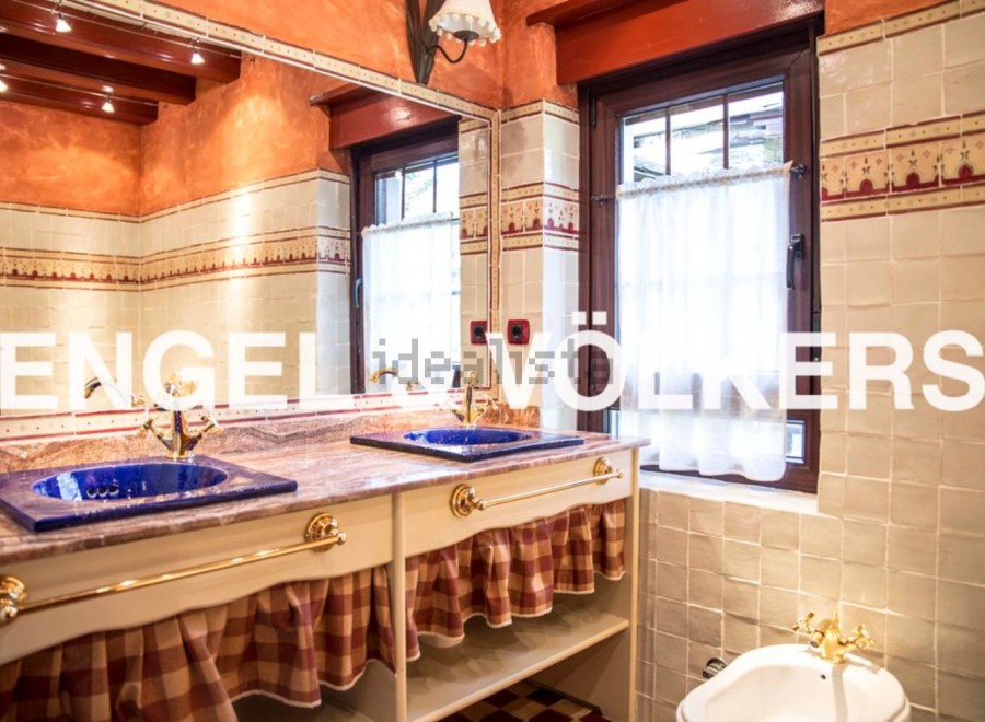 Charming bathroom with double sinks, checkered valance, and vintage-style fixtures.