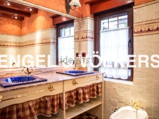 Charming bathroom with double sinks, checkered valance, and vintage-style fixtures.