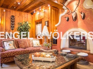 This stunning chalet boasts a cozy living room with a unique fireplace, perfect for relaxing winter evenings.