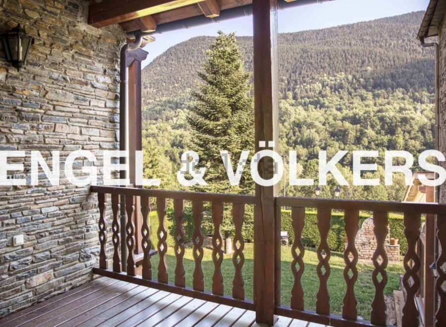 Mountain views from a charming balcony with wooden railings.