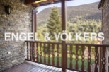 Mountain views from a charming balcony with wooden railings.