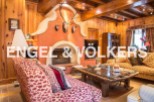 This stunning chalet boasts a spacious living area with a large, ornate fireplace as the centerpiece.