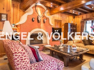 This stunning chalet boasts a spacious living area with a large, ornate fireplace as the centerpiece.