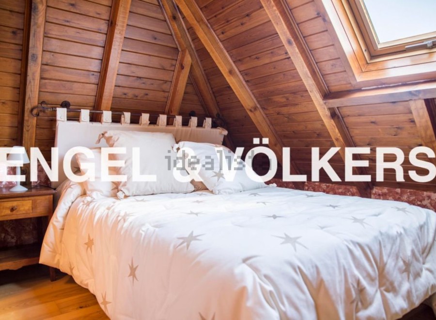 Cosy attic bedroom with wooden beams and skylight.