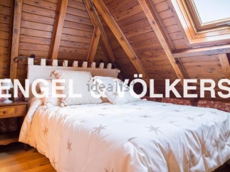 Cosy attic bedroom with wooden beams and skylight.