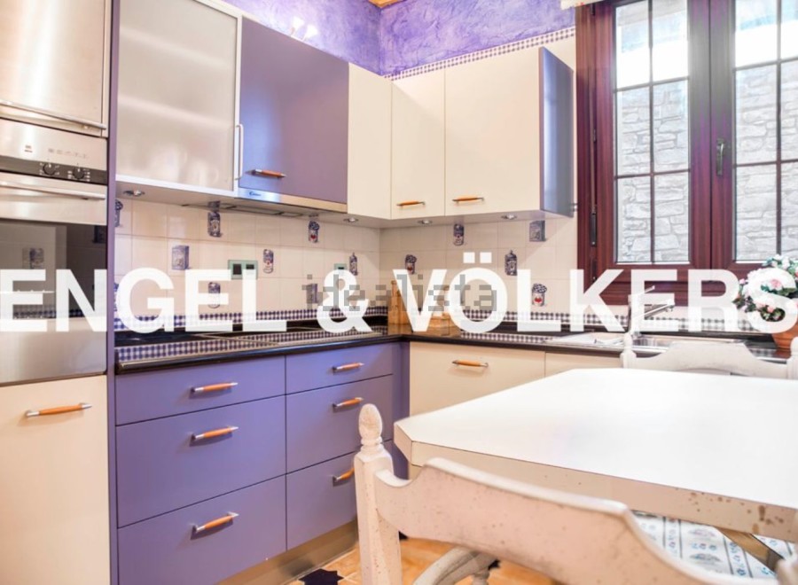 Charming kitchen with purple cabinets and stainless steel appliances.