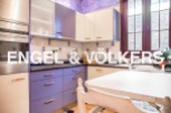 Charming kitchen with purple cabinets and stainless steel appliances.