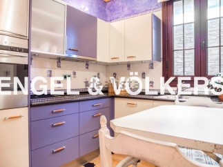 Charming kitchen with purple cabinets and stainless steel appliances.