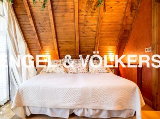 Cosy attic bedroom with wooden beams and large bed.