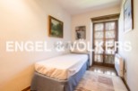 Cozy bedroom with single bed, offering tranquil views through a charming wooden door.