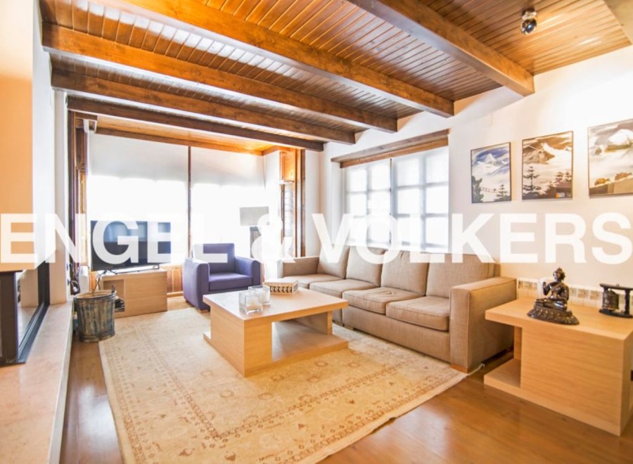 This stunning property boasts a spacious living area with high ceilings and exposed wooden beams, creating a warm and inviting atmosphere.