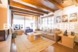 This stunning property boasts a spacious living area with high ceilings and exposed wooden beams, creating a warm and inviting atmosphere.