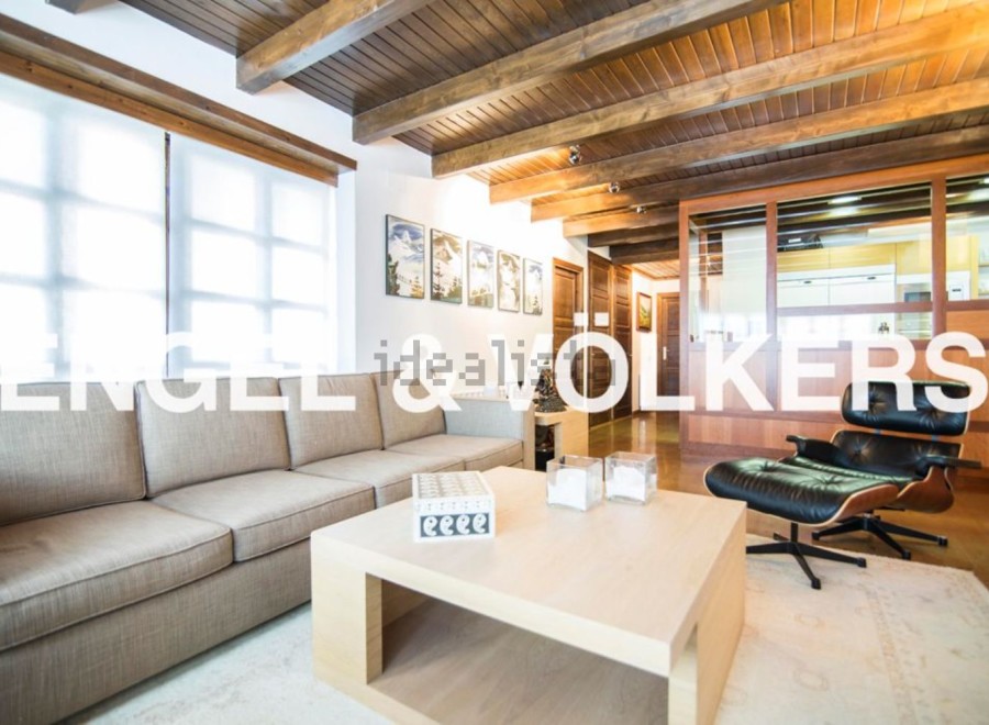 Stunning living room with exposed wooden beams, large windows, and a cozy atmosphere.