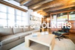 Stunning living room with exposed wooden beams, large windows, and a cozy atmosphere.