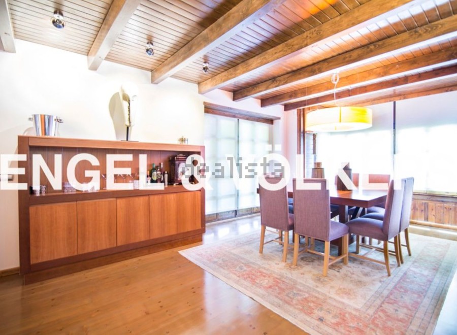 This stunning property boasts a spacious dining area with a wooden ceiling and large windows, creating a bright and airy atmosphere.