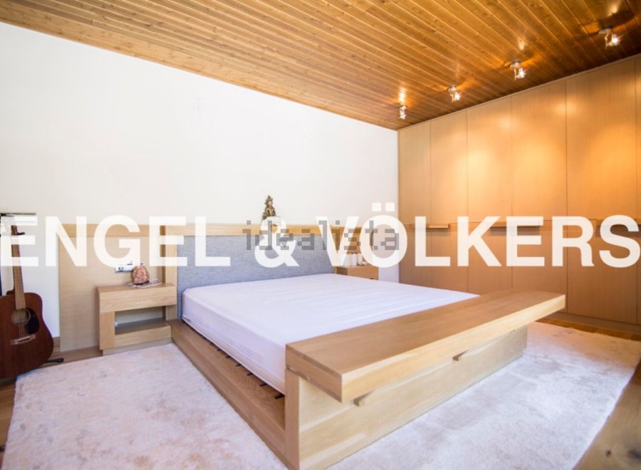 This stunning bedroom boasts a minimalist design with a light oak platform bed and built-in wooden wardrobes.