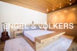 This stunning bedroom boasts a minimalist design with a light oak platform bed and built-in wooden wardrobes.