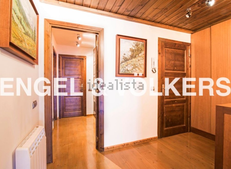 This stunning property boasts a spacious hallway with rich wooden flooring and doors, creating a warm and inviting atmosphere.