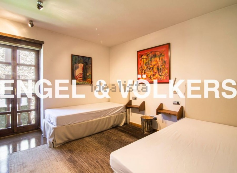 Charming bedroom with twin beds, hardwood floors, and large windows offering ample natural light.