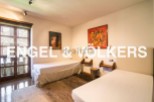 Charming bedroom with twin beds, hardwood floors, and large windows offering ample natural light.