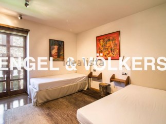 Charming bedroom with twin beds, hardwood floors, and large windows offering ample natural light.