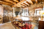 This stunning property boasts a spacious dining room with a large antique wooden table, surrounded by rustic chairs and a beautiful oriental rug.