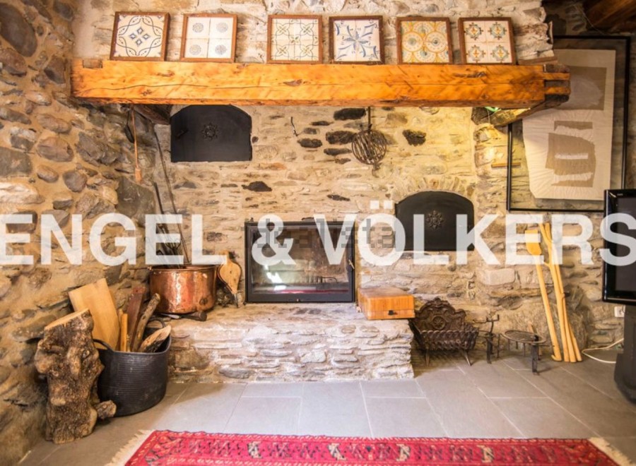 Rustic stone fireplace is the centerpiece of this charming home, complete with antique copper cookware and wood storage.