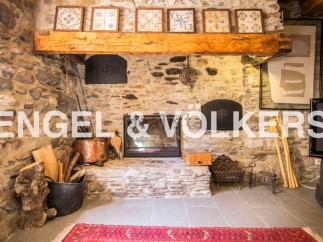 Rustic stone fireplace is the centerpiece of this charming home, complete with antique copper cookware and wood storage.