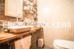 Rustic bathroom with stone wall and wooden vanity.