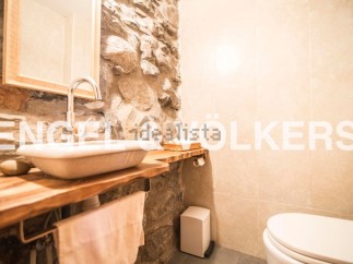 Rustic bathroom with stone wall and wooden vanity.