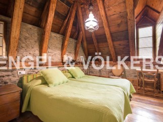 Cosy attic bedroom with exposed wooden beams and stone walls.