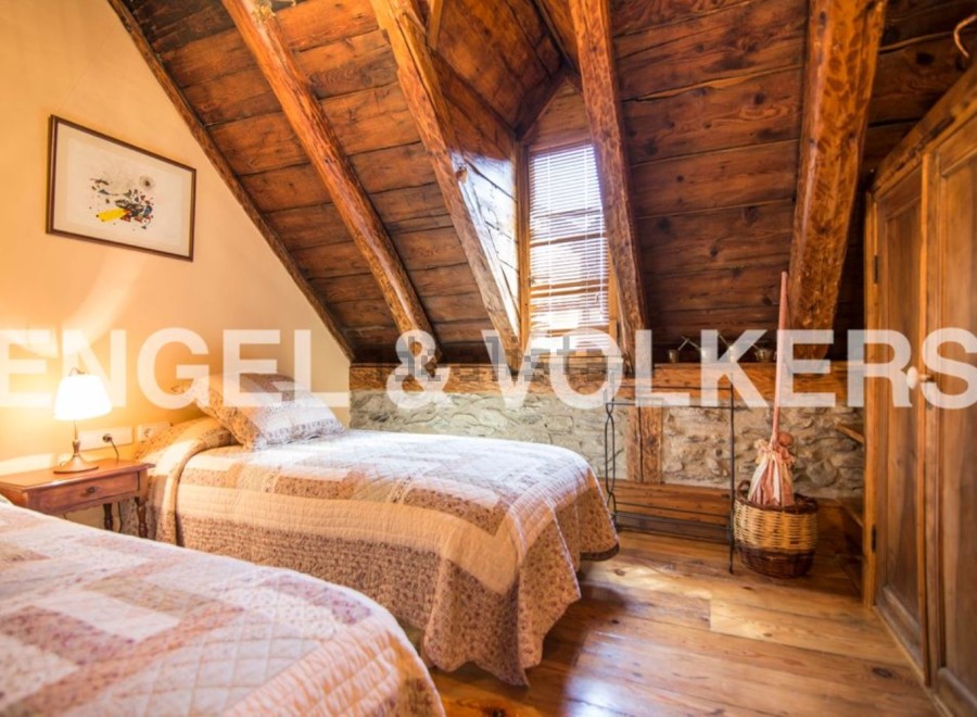 Charming rustic bedroom with exposed wooden beams and stone walls.