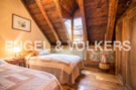 Charming rustic bedroom with exposed wooden beams and stone walls.