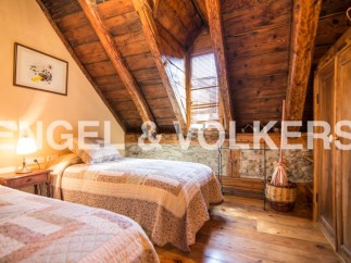 Charming rustic bedroom with exposed wooden beams and stone walls.