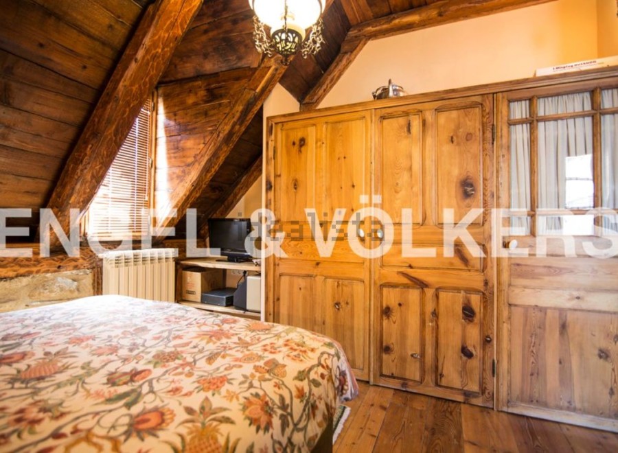 Charming rustic bedroom with wooden beams and built-in wardrobe.