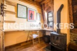 Charming attic room with wooden beams, featuring a built-in desk and a wood-burning stove.