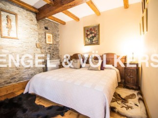 Cosy bedroom with stone walls and wooden beams, offering a rustic charm.