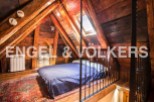 Charming attic bedroom with exposed wooden beams and skylight.