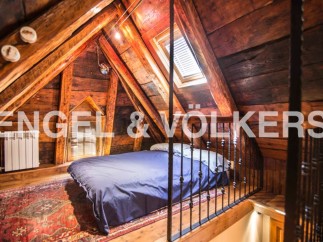 Charming attic bedroom with exposed wooden beams and skylight.