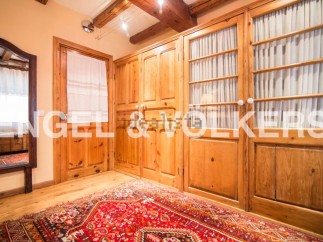 This charming bedroom boasts beautiful wooden built-in wardrobes with glass panel doors and curtains, offering ample storage space.
