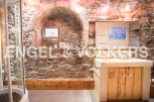 Rustic bathroom with stone walls and wooden vanity.