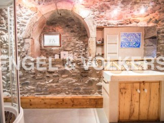 Rustic bathroom with stone walls and wooden vanity.