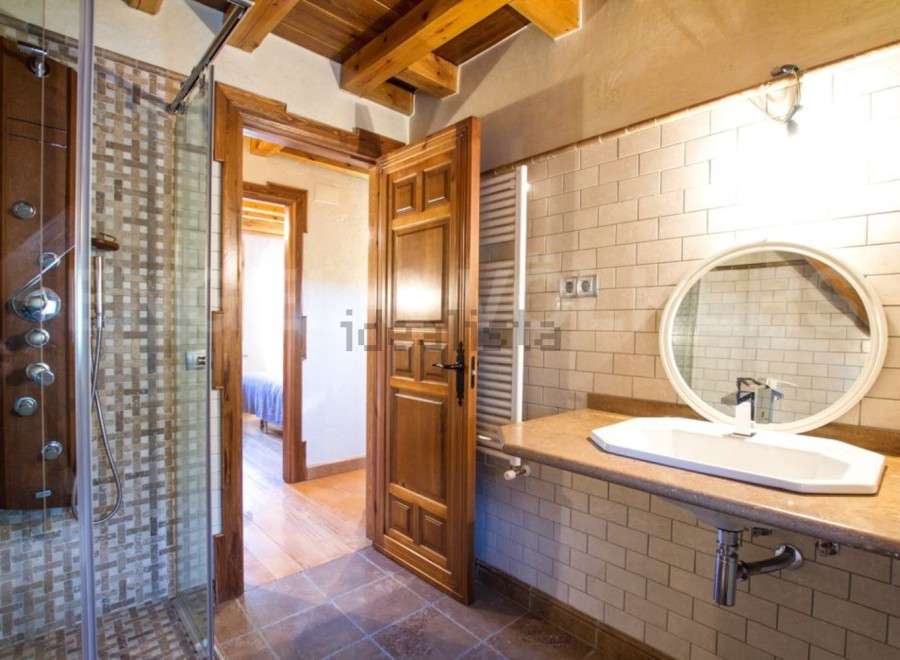 This stunning bathroom boasts a spacious shower with multiple shower heads and a modern, sleek design.