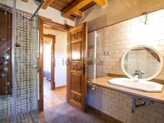 This stunning bathroom boasts a spacious shower with multiple shower heads and a modern, sleek design.