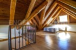 This stunning attic bedroom boasts a beautiful wooden beam ceiling and hardwood floors.
