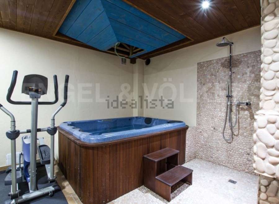 This luxurious property boasts a stunning indoor spa area, complete with a jacuzzi and a pebble-tiled shower.